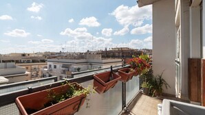 A balcony with potted plants and a view of the cityscape. - GuestHost - Bright apartment of about 100 sqm, perfect for 3 people, located on the seventh floor of a building with elevator (NOT suitable for disabled people - some steps to access it).The property is located in a quiet residential area well connected  (Rome)