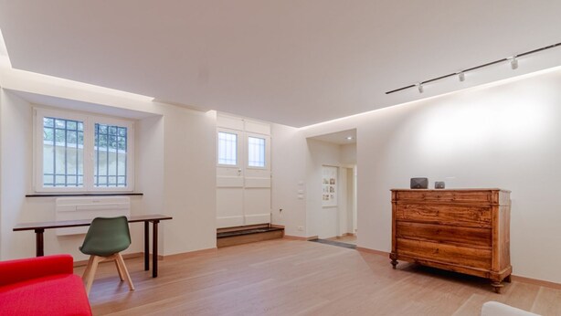 A spacious room with a desk, chair, and a wooden dresser.