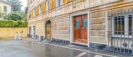A building with a stone facade, a wooden door, and a metal gate.