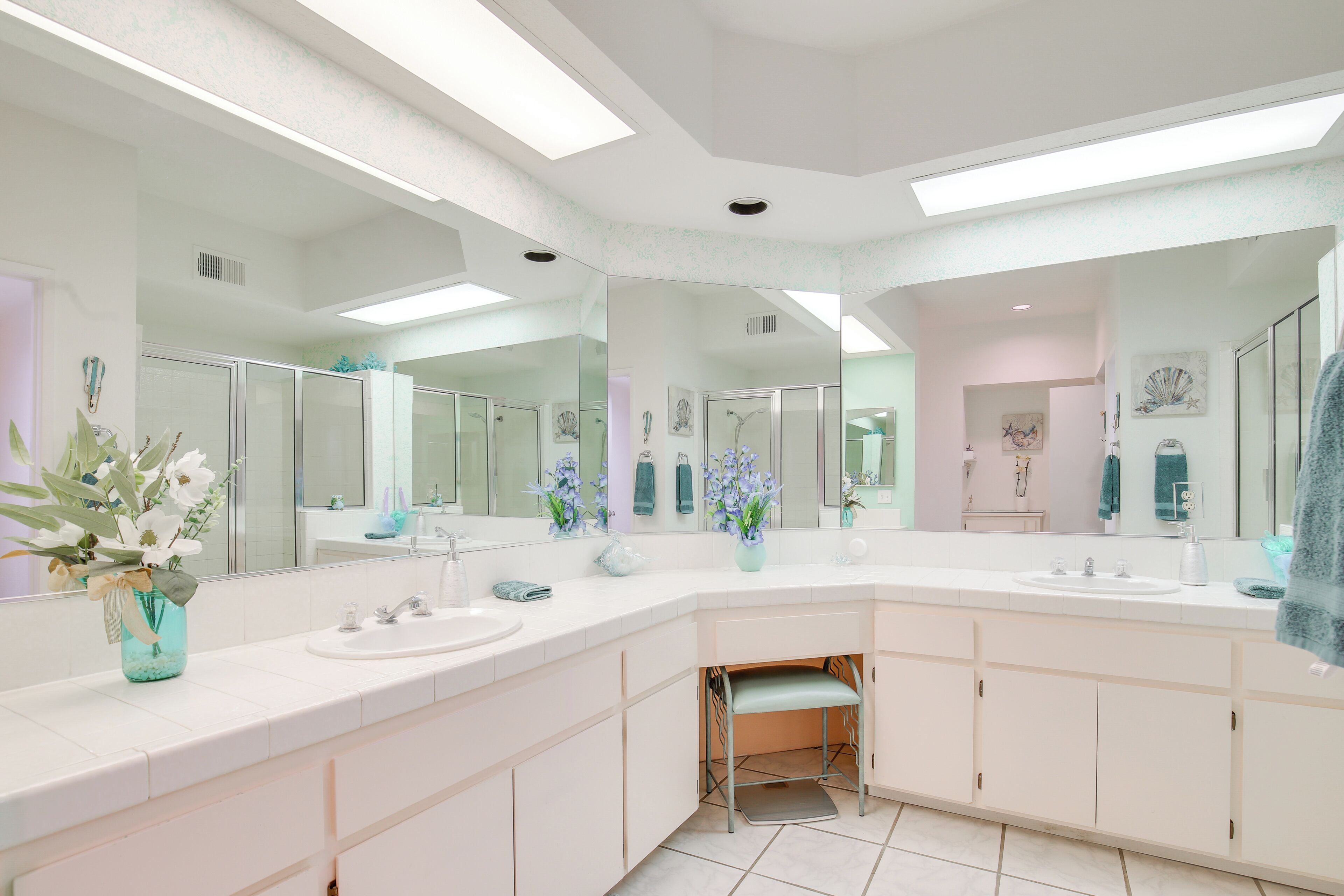 Een moderne badkamer met twee wastafels, een grote spiegel en een opbergmeubel.