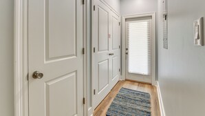 A hallway with white doors, a blue patterned rug, and a ceiling light. - Walk to Beach & Harbor: Dtwn Pass Christian Home (Pass Christian)