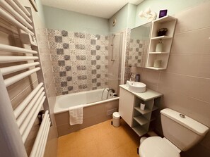 A bathroom with a bathtub, toilet, and sink. - Sète – T2 avec piscine, parking – 2 pas des plages (Sète)