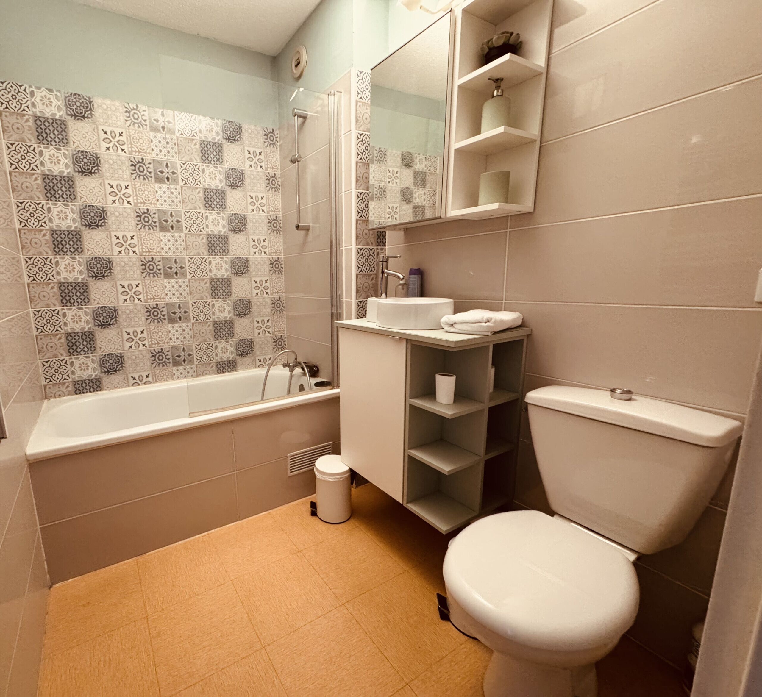 A bathroom with a bathtub, toilet, and a sink.