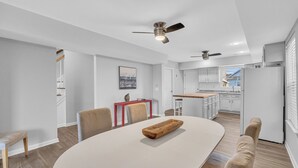 A modern kitchen with white cabinets, a wooden countertop, and a built-in oven.