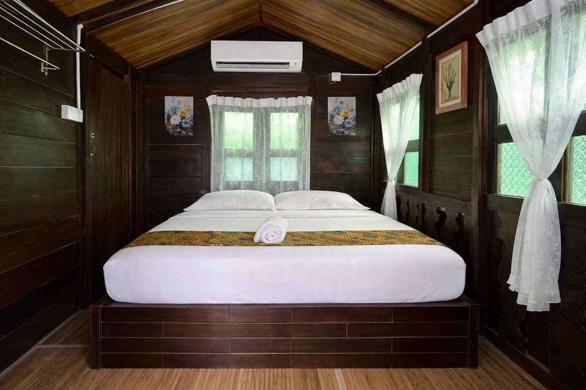 Um quarto tipo cabana de madeira com uma cama grande, paredes de madeira e teto inclinado.