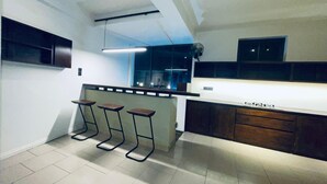 A modern kitchen with a bar area, built-in cabinets, and a large window. - Hidden Negombo by Sana's (Negombo)