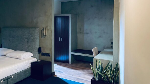 A modern bedroom with a large bed, a wardrobe, a desk, and a potted plant. - Hidden Negombo by Sana's (Negombo)