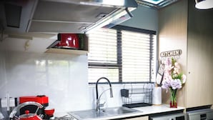 Una cucina moderna con un bollitore rosso, una lavatrice Siemens e una finestra con persiane.