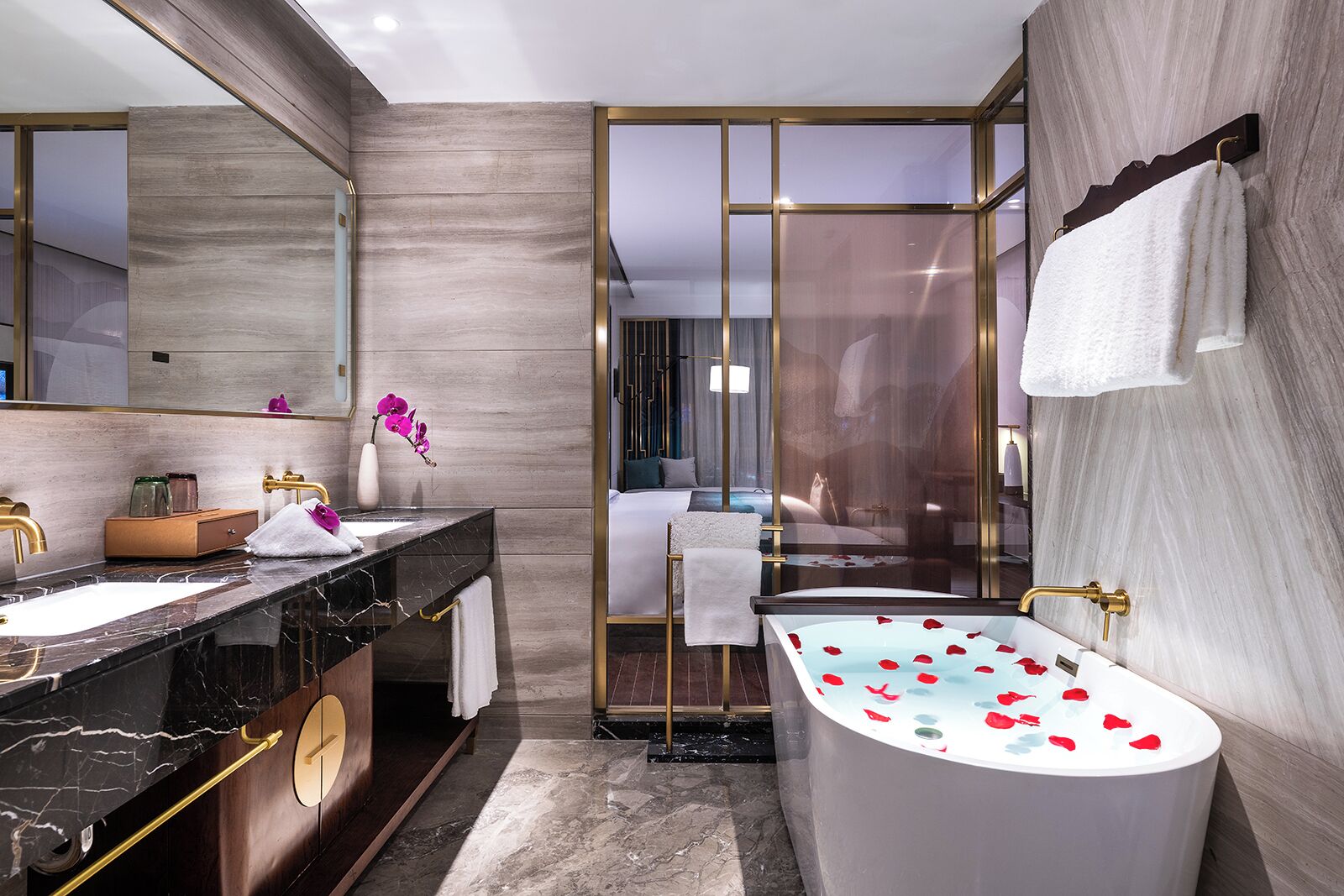 Une salle de bain moderne avec un meuble-lavabo en marbre, une baignoire sur pieds et une douche séparée par des parois en verre.