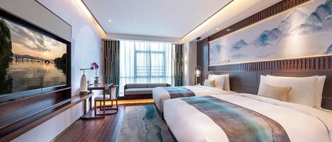 Una habitación de hotel moderna con una cama grande, un escritorio y un televisor que muestra una vista panorámica.