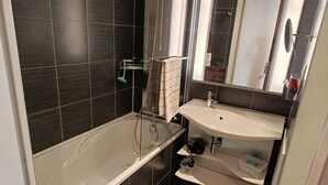 Une salle de bain moderne avec une baignoire, un lavabo et un miroir.