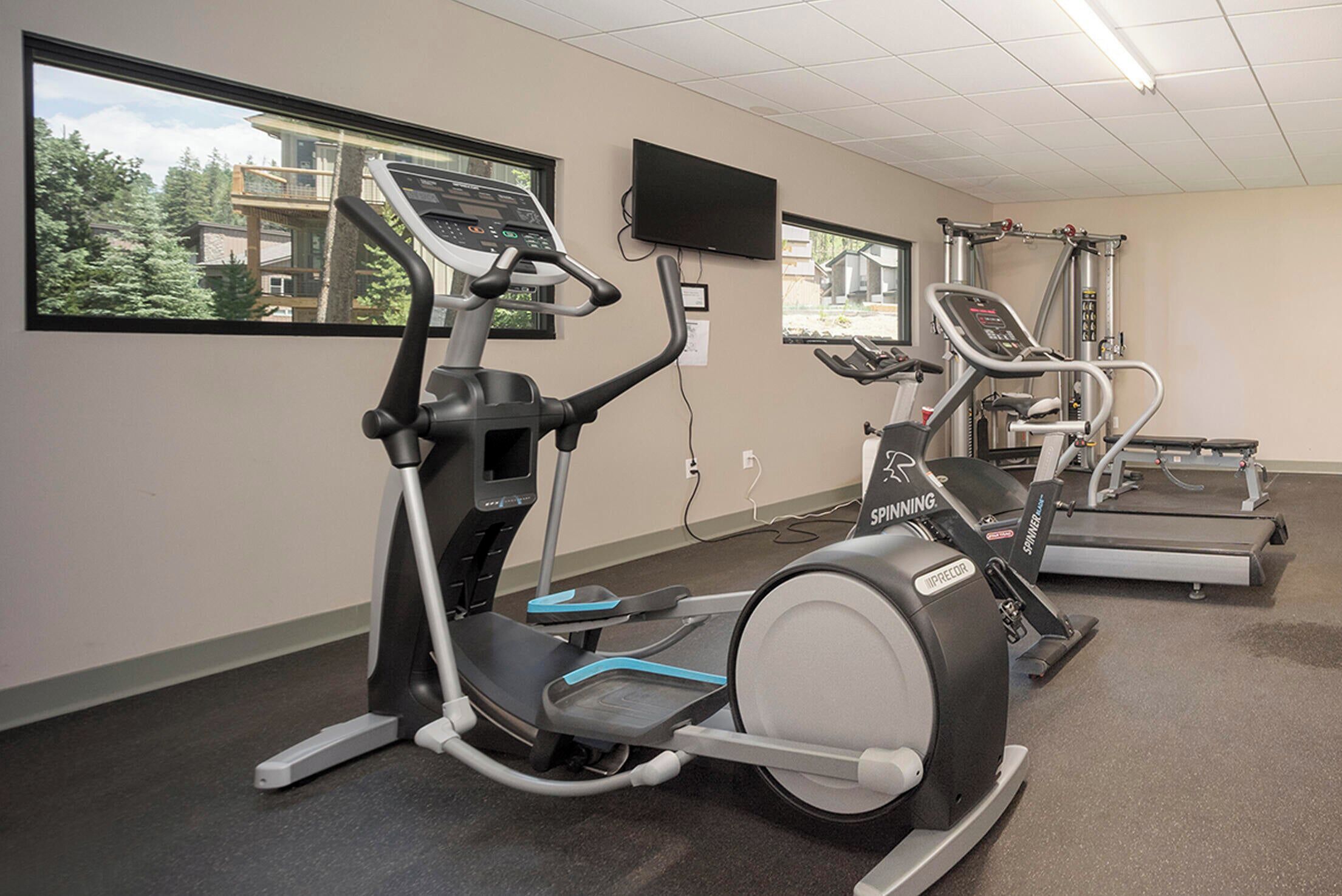 A gym with treadmills, an elliptical, and a stationary bike.