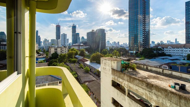 A high-rise building with a view of a cityscape, including several tall buildings and a clear sky. - Petch Tower Ekkamai (Bangkok)
