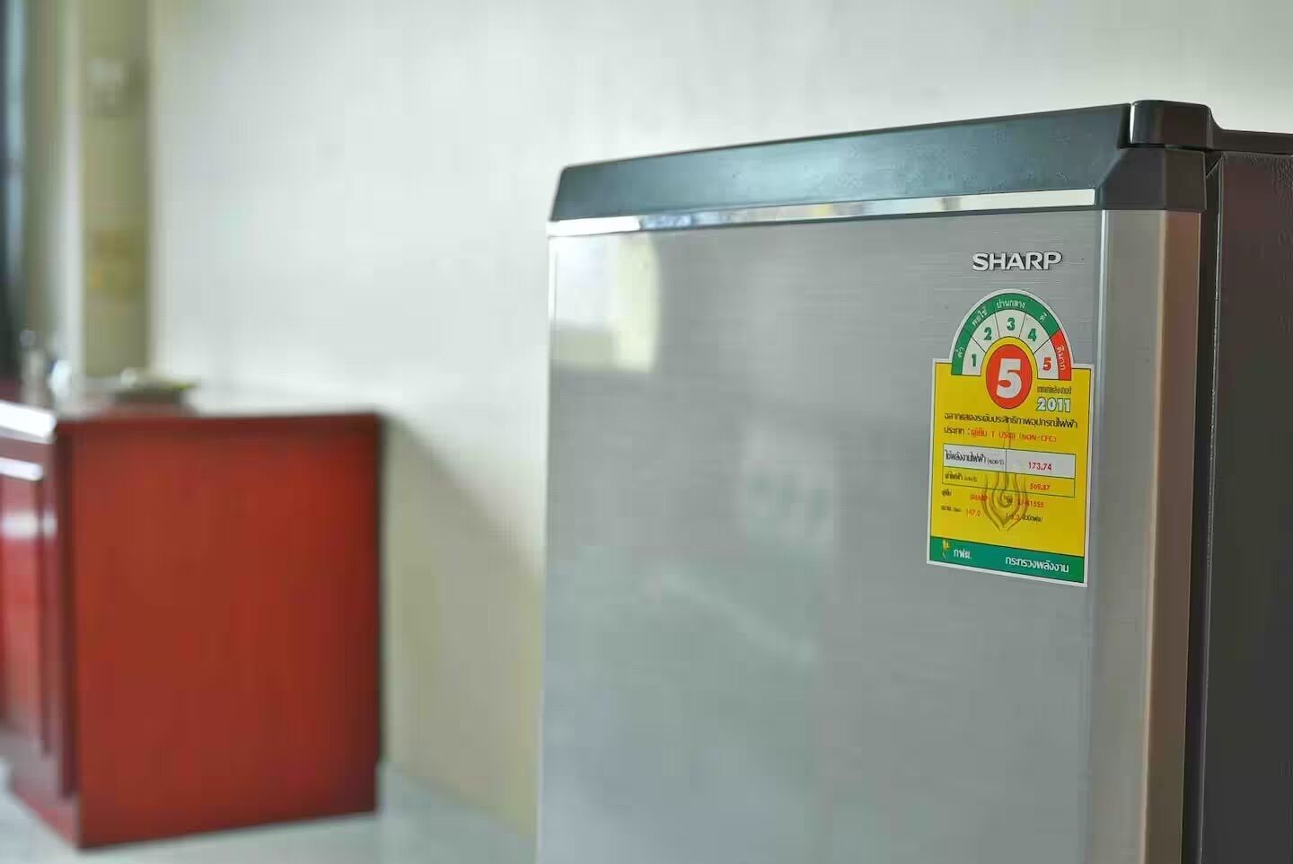 A stainless steel refrigerator with a sticker indicating a 5-star rating and a price of 173.74.