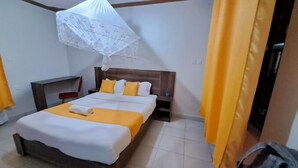 Une chambre d’hôtel avec un lit, une table de chevet, une chaise et une valise.