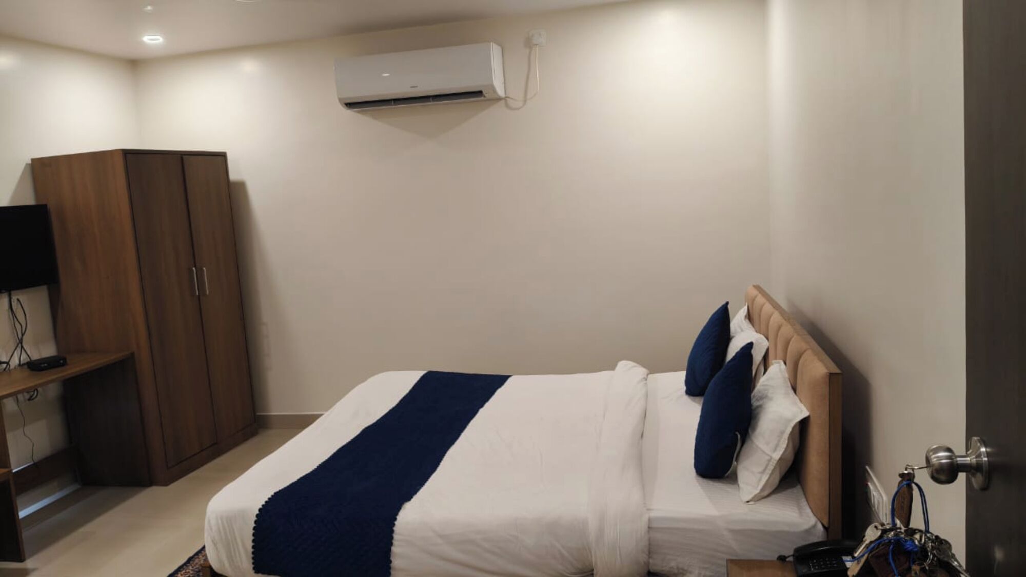 Une chambre d’hôtel équipée d’un lit, d’une armoire, d’un téléviseur et d’un appareil de climatisation.
