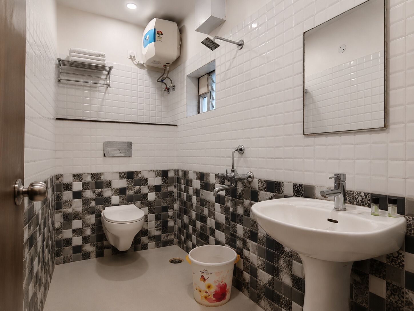 Un baño con inodoro blanco, lavamanos y ducha.