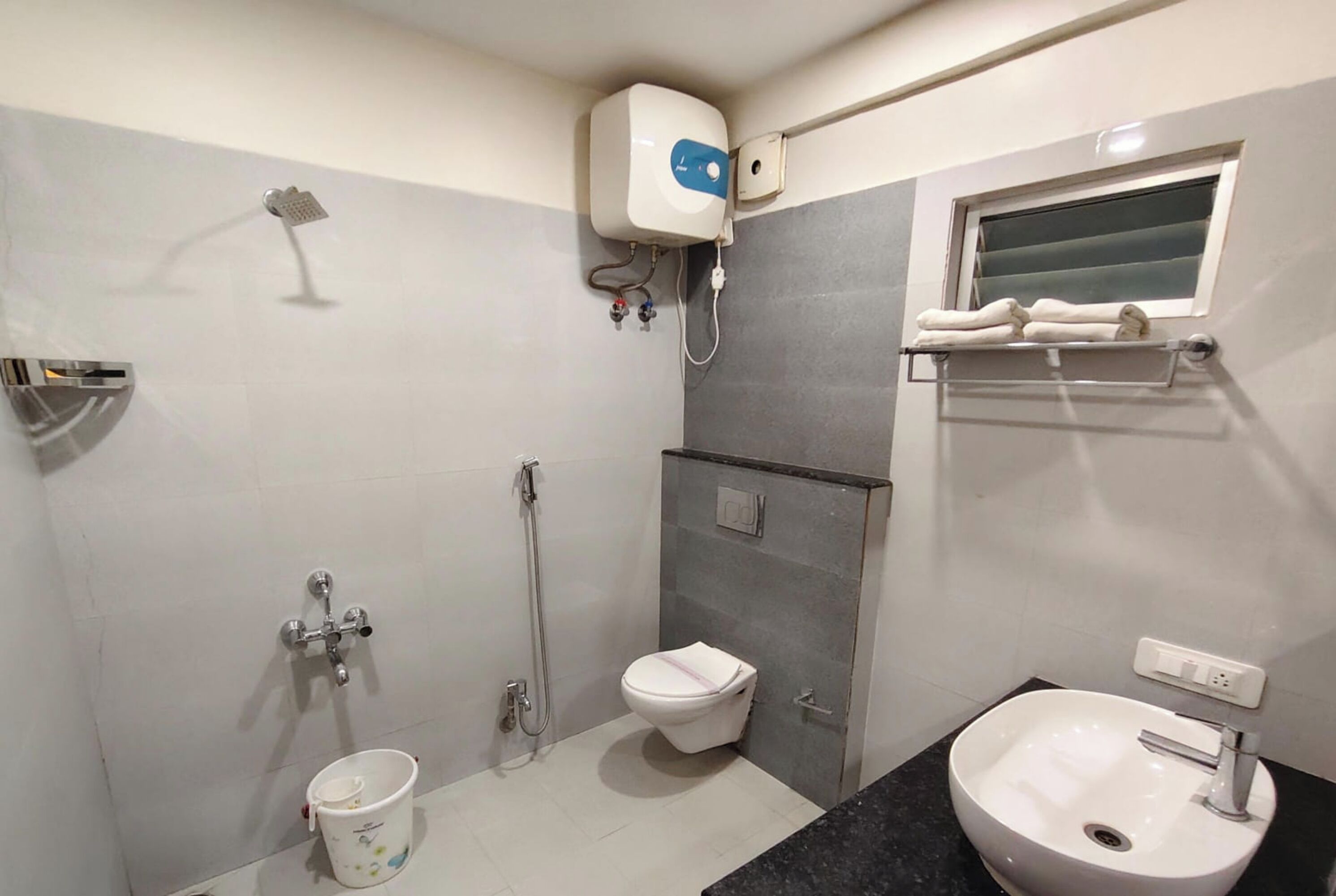 Un baño con inodoro, bidé, lavamanos y ducha.
