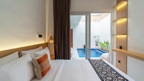A hotel room with a large bed, a view of a swimming pool, and a sliding door leading to an outdoor area. - Casa De Vero Amore 3 (Jimbaran)