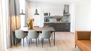 Een moderne keuken met donkere kastjes, een magnetron en een roestvrijstalen afzuigkap.