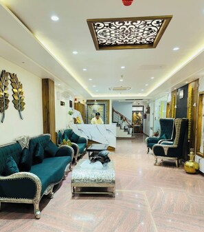 A spacious living area with a marble floor, a central coffee table, and two sofas. - RUDRA GANGA HOTEL (Varanasi)