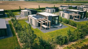Ein moderner Wohnkomplex mit mehreren freistehenden Häusern, jedes mit großen Fenstern und Solaranlagen.