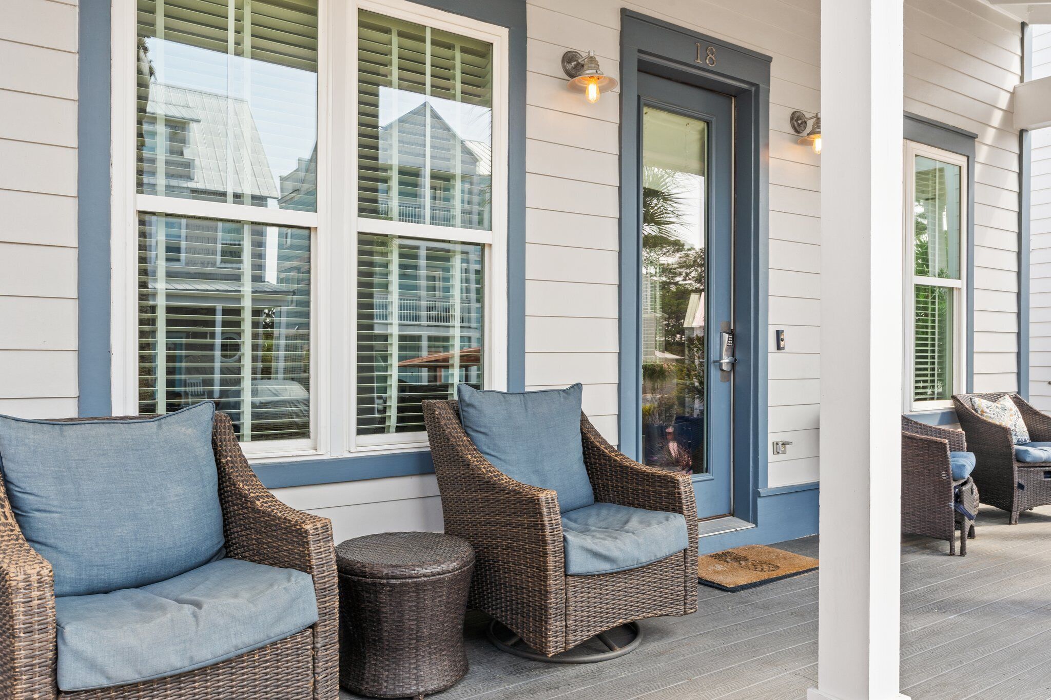 A porch with wicker furniture, a door, and windows.