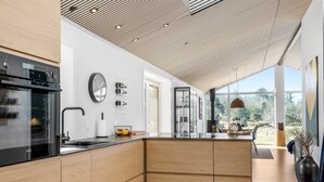 Una cocina moderna con armarios de madera, horno empotrado y una isla grande.