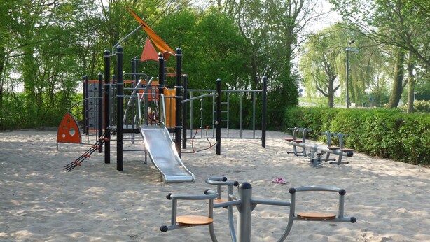 Zona de jocs amb diferents elements, com tobogans, estructures per escalar i espais d'exercici.