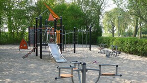 A playground with various equipment including a slide, climbing structures, and exercise stations. - Country Home with Sauna (Zevenhuizen)