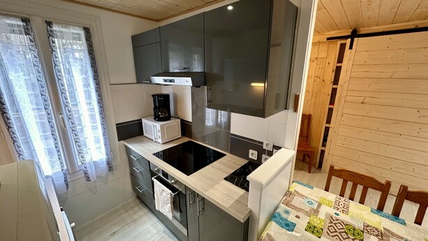 A compact kitchen with a microwave, stove, and coffee maker.