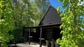 Un chalet rustique doté d’un toit en pente, entouré d’une végétation luxuriante.