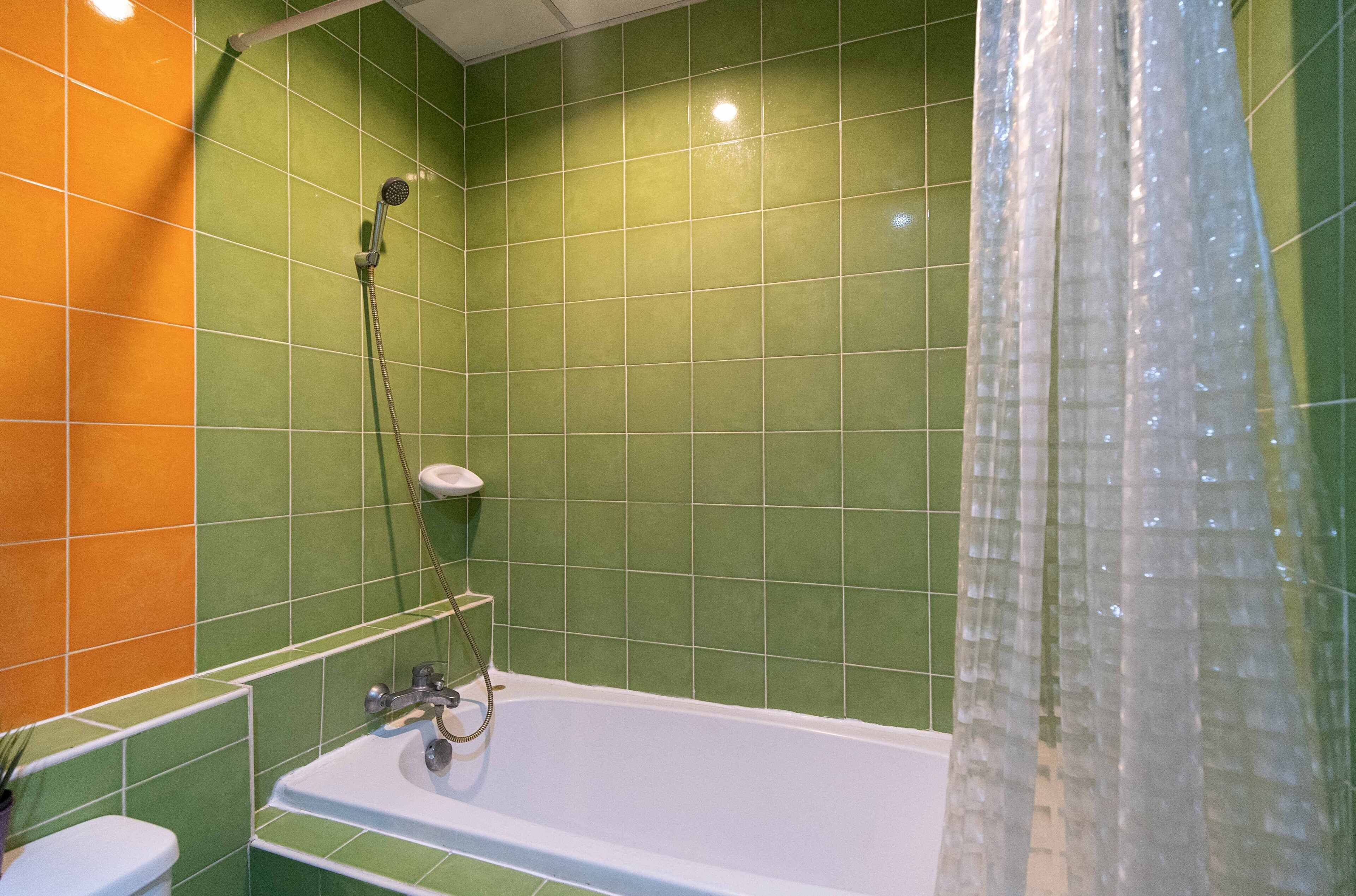 Un baño con bañera, ducha y retrete.