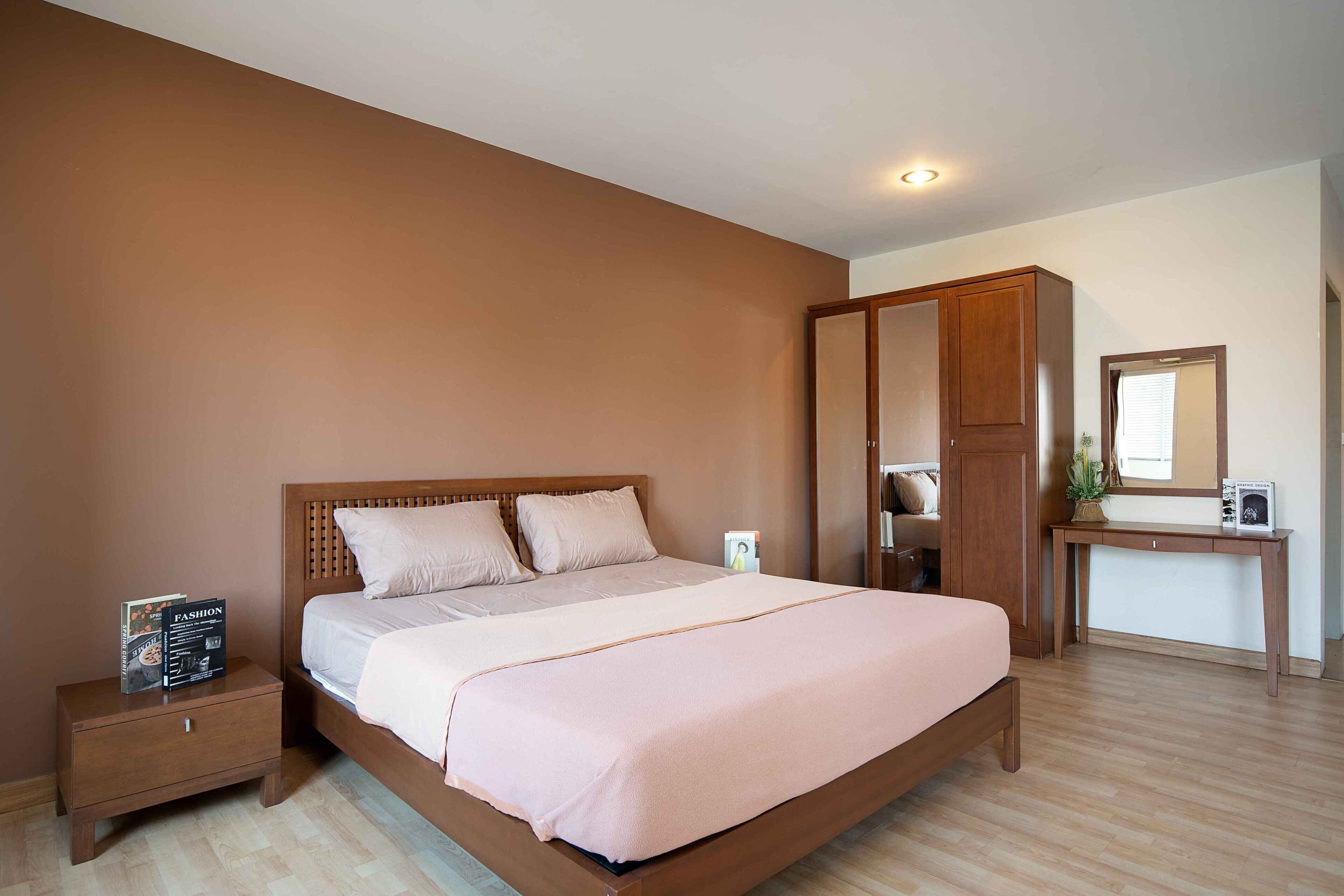 A bedroom with a wooden bed, nightstand, and wardrobe.