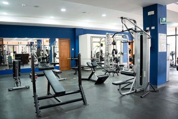 A gym with various exercise equipment, including free weights and cardio machines. - Brand New Ocean View Condo (Cabo Velas)