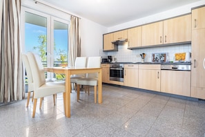 Una cocina moderna con comedor, ventanas amplias y vistas al exterior.