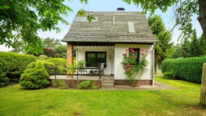 A house with a covered porch, a small garden, and a well-maintained lawn. - Holiday Home 'Carpin' with Private Terrace, Garden and Wi-Fi (Carpin)