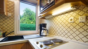 A kitchen with a window, a stove, a coffee maker, and a sink. - Holiday Home 'Carpin' with Private Terrace, Garden and Wi-Fi (Carpin)