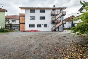 Un immeuble à plusieurs étages, doté d’un toit plat, d’un escalier central et d’une cour recouverte de gravier.