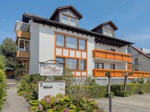 Un hôtel avec une enseigne indiquant « Vita Mari Hotel Garni », un balcon avec des balustrades orange et une boîte aux lettres portant le numéro 3.