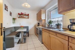 Una cocina moderna con horno empotrado, lavavajillas y ventana con vistas.