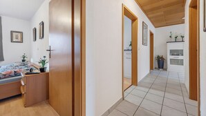 Un dormitorio con cama, armario de madera y una pequeña escritorio con planta.