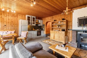 Um interior acolhedor em madeira, com área de jantar, cozinha e espaço para sentar.
