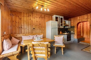 L’intérieur d’un chalet en bois comprend un coin repas, une cuisine et un espace salon confortable.