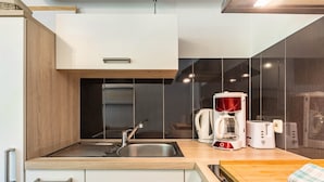 Een moderne keuken met een roestvrijstalen spoelbak, een koffiezetapparaat en een broodrooster.