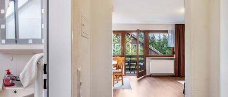 A modern interior with a bathroom, a dining area, and a view of the outdoors.