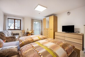 A hotel room with a bed, a TV, a desk, and a wardrobe.