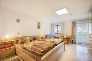 Une chambre à coucher avec un lit en bois, des tables de chevet, un bureau et une chaise.