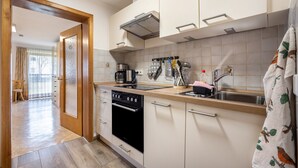 A kitchen with a stove, oven, sink, and various utensils.