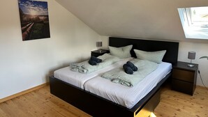 A bedroom with a bed, two bedside tables, a night lamp, a wall-mounted picture, and a skylight. - Apartment 'Tanne' with Mountain View and Wi-Fi (Höchenschwand)